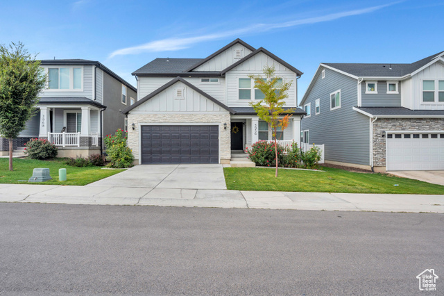 House featuring a front yard, a garage, and covered porch