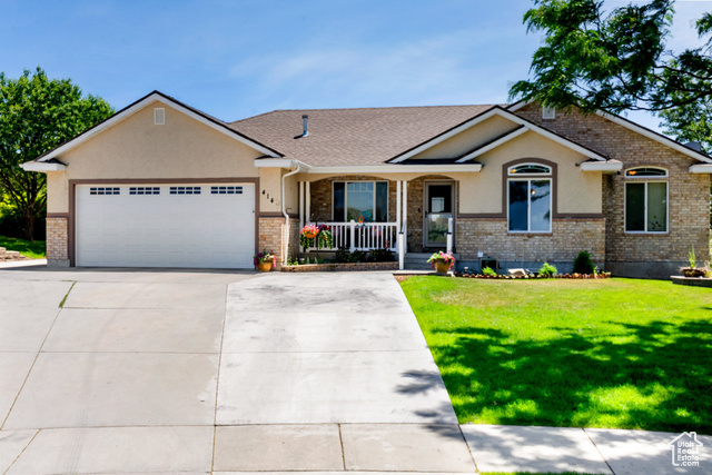 View of front facade featuring a garage and a front yard