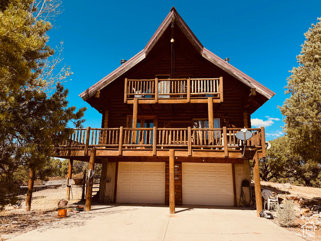 View of front of property with a balcony and a garage