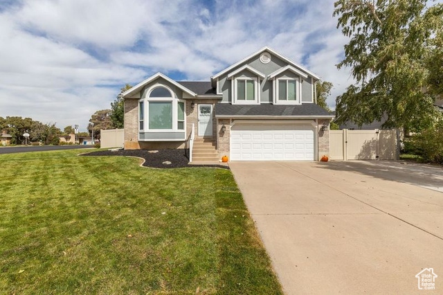 View of front of property with a garage and a front lawn