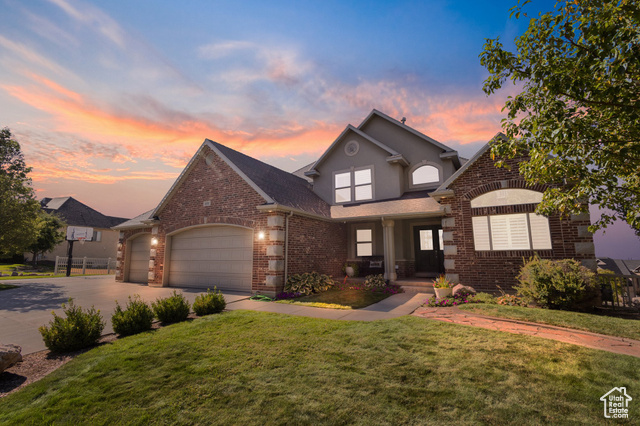 View of front of house featuring a garage and a yard