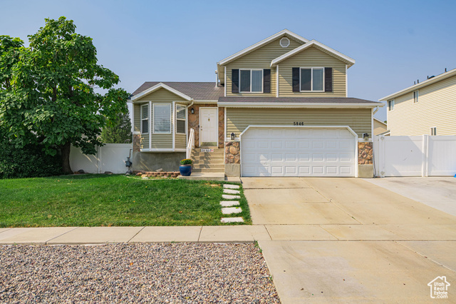 View of front of home with a garage and a front yard