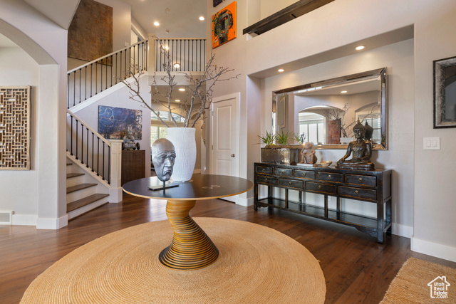 Double volume entryway foyer w/ hardwood flooring, grand stairway & art niche wall w/ recessed ambient lighting.