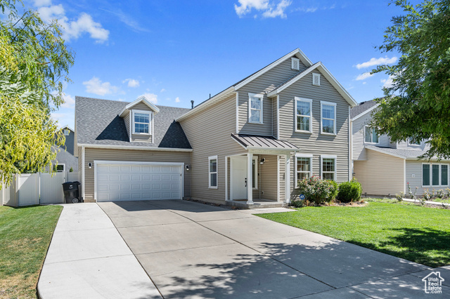 Front facade featuring a front yard and a garage