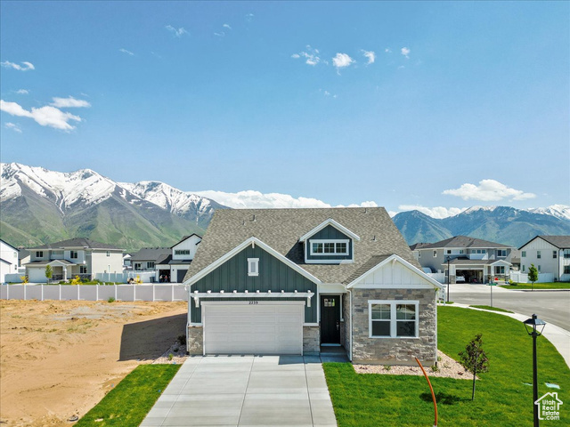 View of front of property featuring a mountain view and a front yard