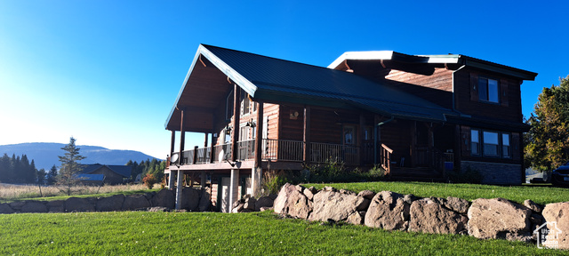 View of property exterior featuring a lawn and a mountain view