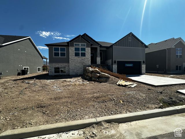 View of front facade featuring central AC unit and a garage