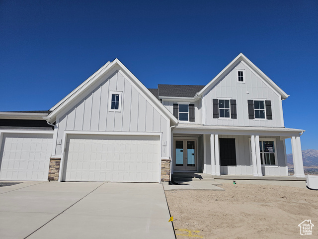 View of front facade featuring a porch and a garage