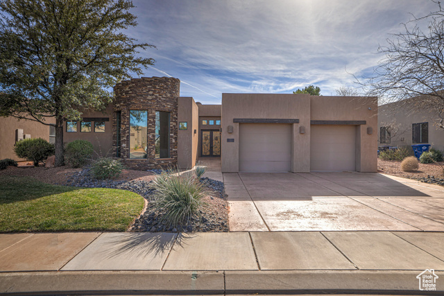 Pueblo revival-style home featuring a garage