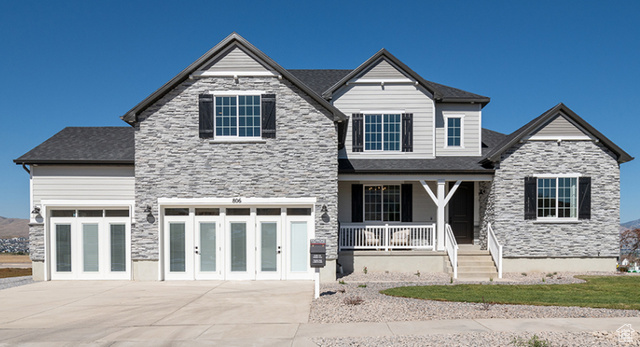 View of front of home with a garage and covered porch. Disclaimer: Photos are of a Jessica model but not the subject property.