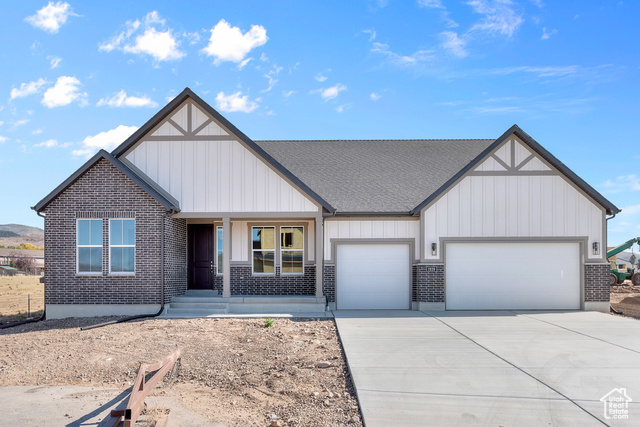 View of front of home with a garage and a porch