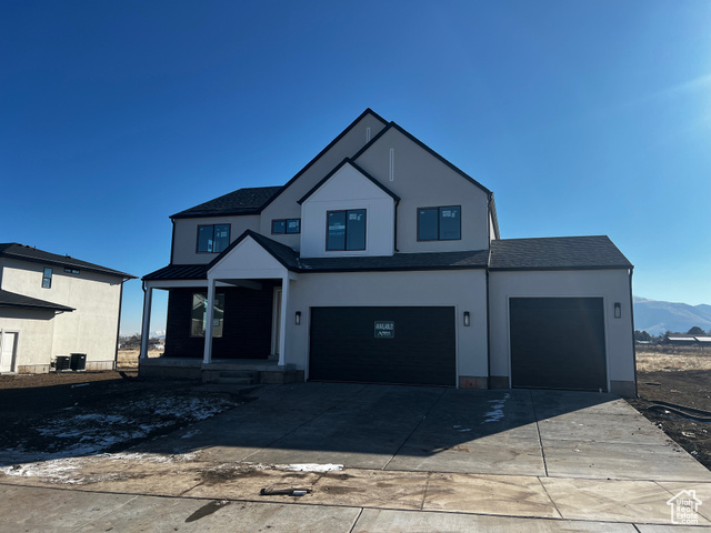 View of front of property with a garage and a mountain view