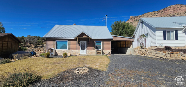 View of front of property featuring a garage and a front lawn