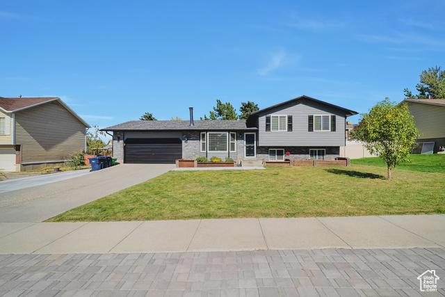 Tri-level home with a garage and a front lawn