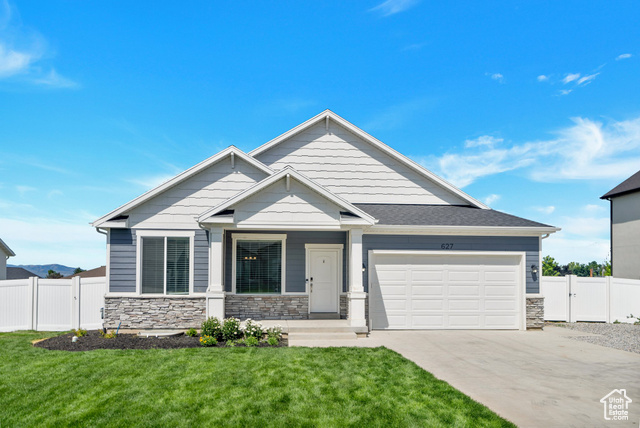 Craftsman-style house featuring a garage and a front yard