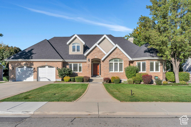 View of front facade featuring a front lawn and a garage