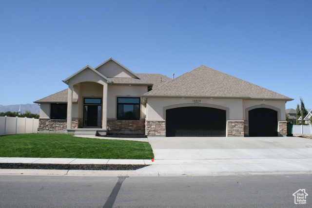 View of front of home featuring a garage and a front yard