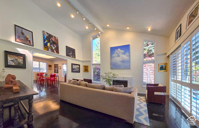 Living room with a towering ceiling and dark wood flooring, featuring a fire place