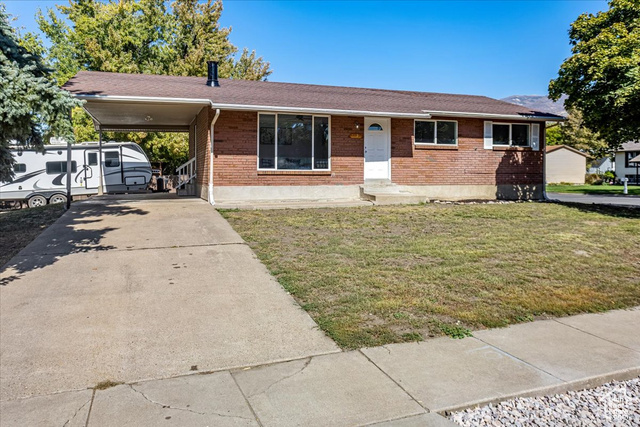 View of front of home with a front lawn and a carport