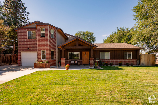 View of front of house with a front yard and a garage