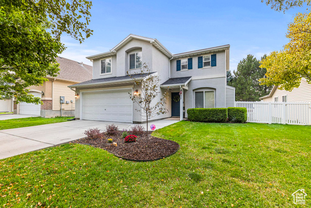 Front of property featuring a front yard and a garage