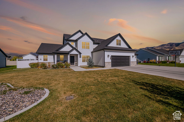 Craftsman-style home featuring a garage and a yard