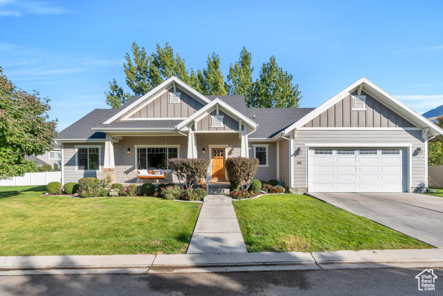 Craftsman house featuring a front yard, a garage, and a porch