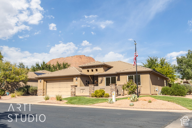 View of front of home with a mountain view and a garage