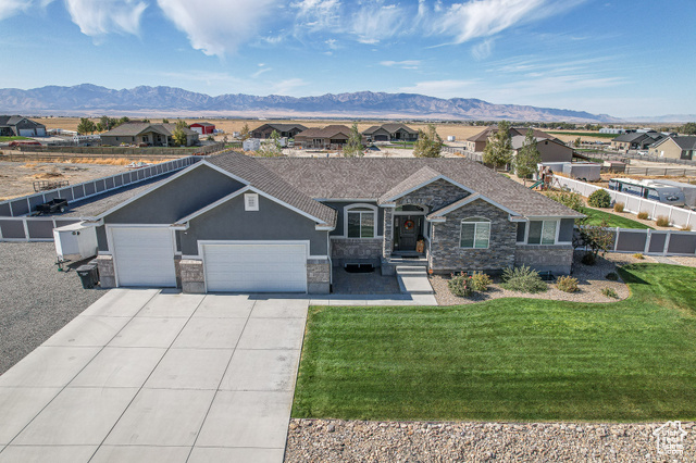 Ranch-style house with a front lawn, a mountain view, and a garage