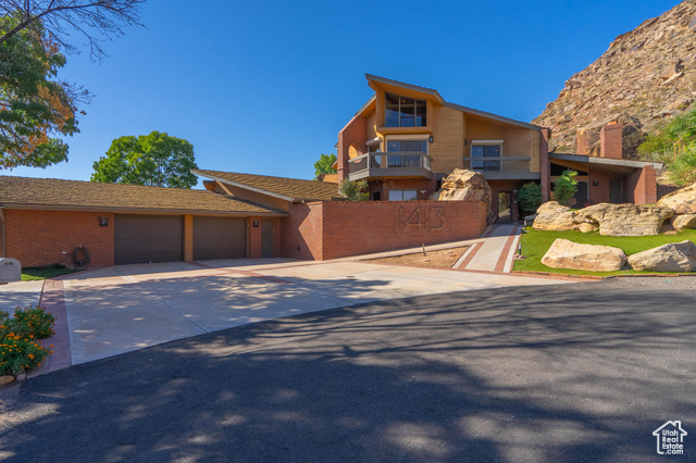 View of front of home featuring a garage and a balcony