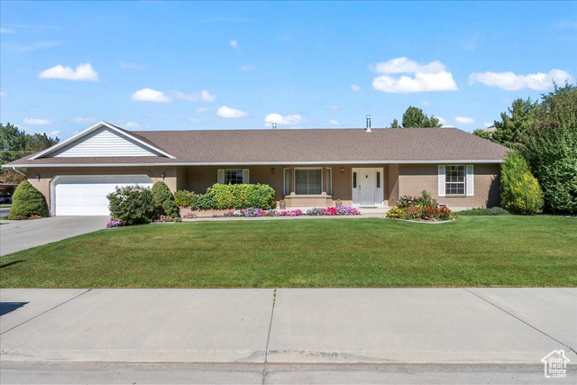 Single story home with a front yard and a garage