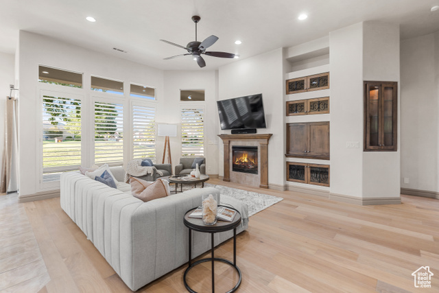 Living room featuring ceiling fan and light hardwood / wood-style floors