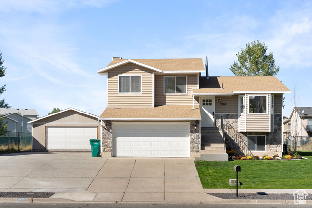 View of front of home featuring a front lawn and a garage