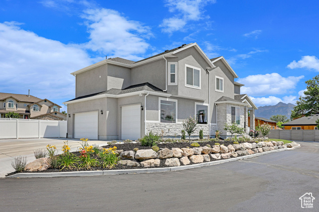 View of front of property with a garage and a mountain view