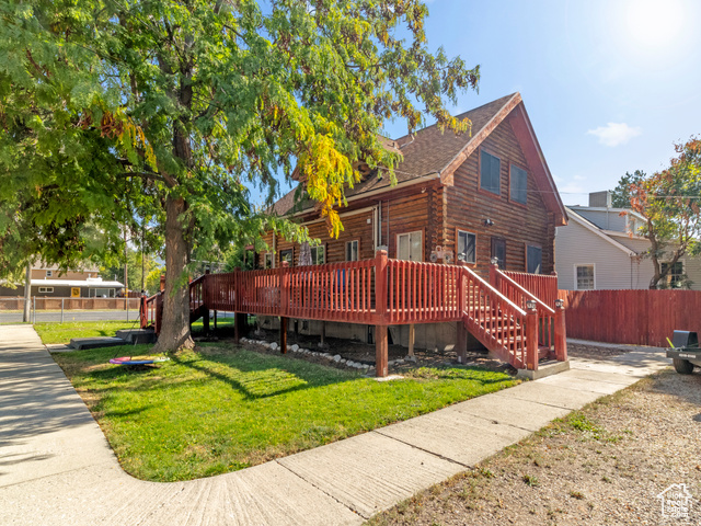 Exterior space with a front lawn and a deck