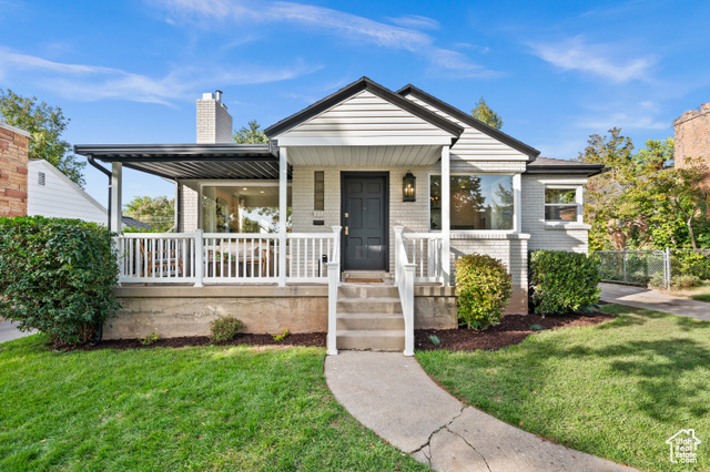 View of front of home with a front yard and a porch