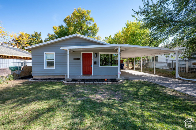 View of front of home with a front lawn and a carport