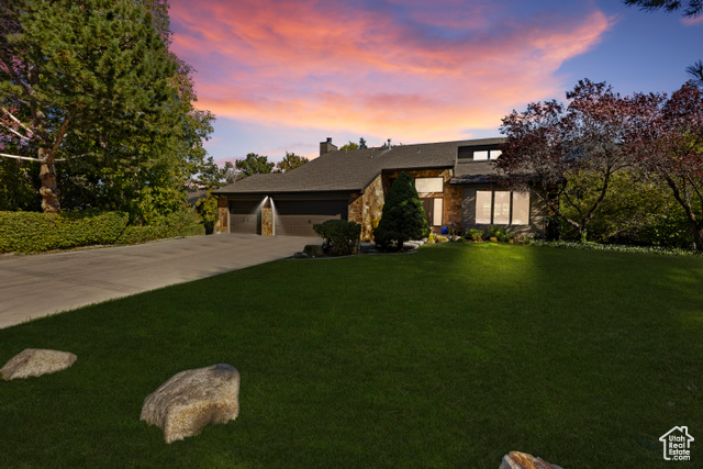 View of front facade with a yard and a garage