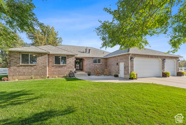 Single story home featuring a front yard and a garage