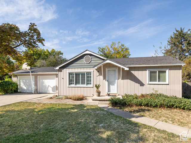 Ranch-style house featuring a garage and a front lawn