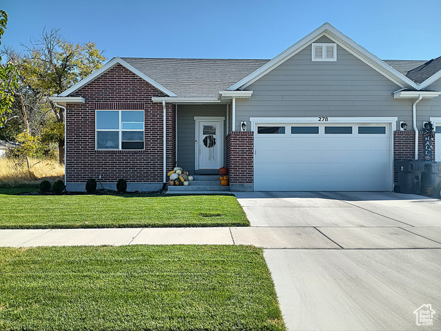 View of front of home featuring a garage and a front lawn