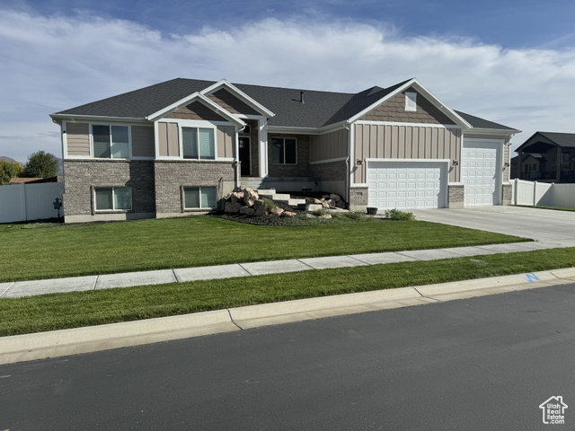 View of front of property featuring a front lawn and a garage