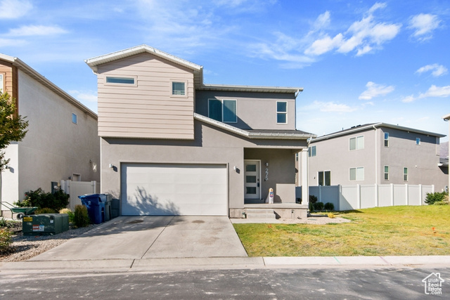 View of front property with a garage and a front lawn