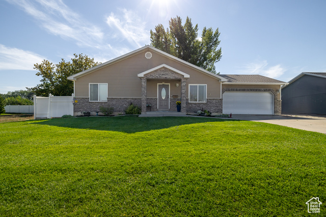 View of the front yard. House has natural stone, vinyl siding and attached 2-car garage.