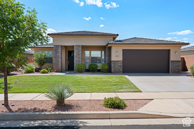 Prairie-style house featuring a front yard and a garage