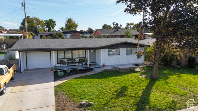 Single story home with a front yard and covered porch