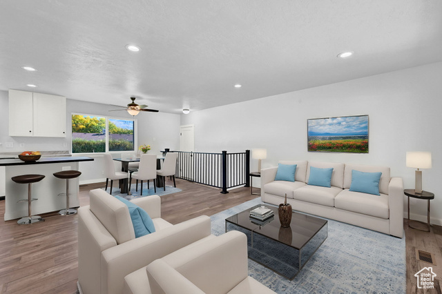 Living room featuring ceiling fan and light hardwood / wood-style flooring