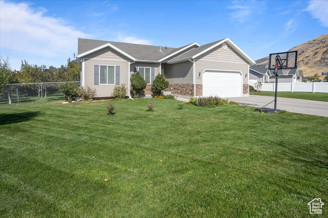 View of front facade featuring a garage and a front lawn