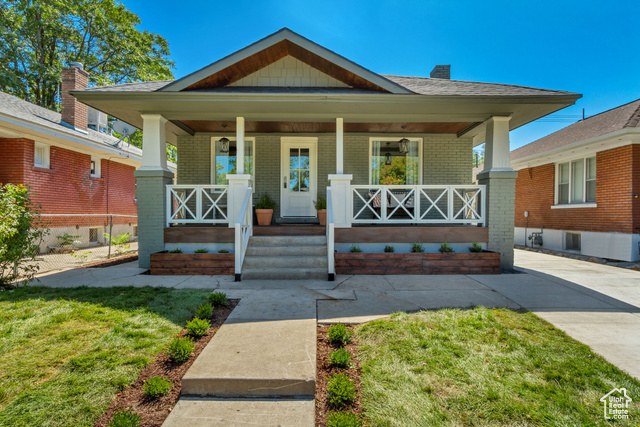 Bungalow-style house with a front lawn and covered porch