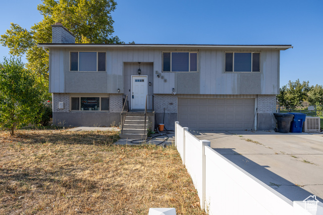 Bi-level home featuring central air condition unit and a garage